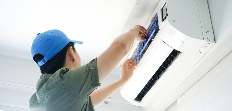 Male repair air conditioner at room, He is air technician , mechanic , engineer. Maintenance air conditioner myself.